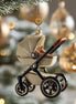 Golden baby stroller Christmas ornament hanging in tree, first Christmas keepsake